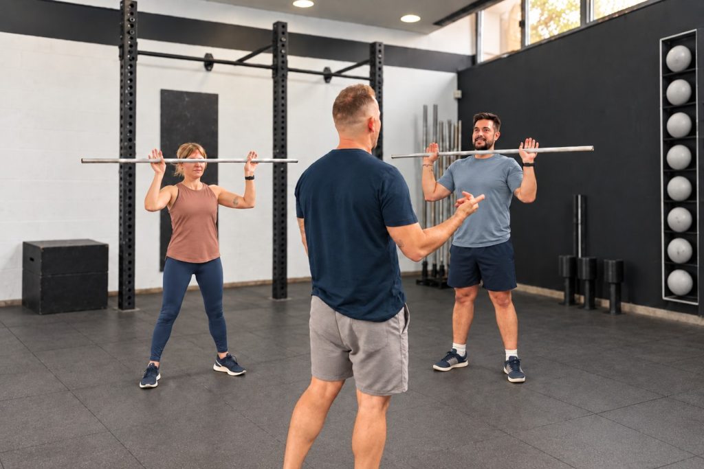 Dos clientes entrenando con picas y su entrenador en Estudio Training Bilbao